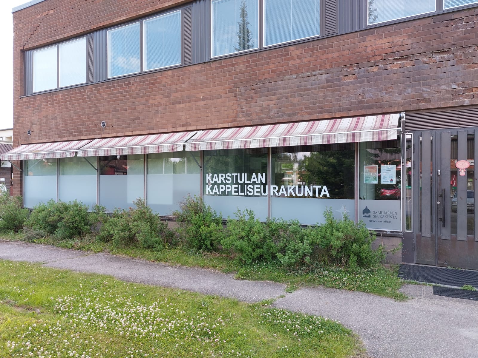 Karstulan väistötilan julkisivu. Ikkunassa teippaus Karstulan kappeliseurakunta