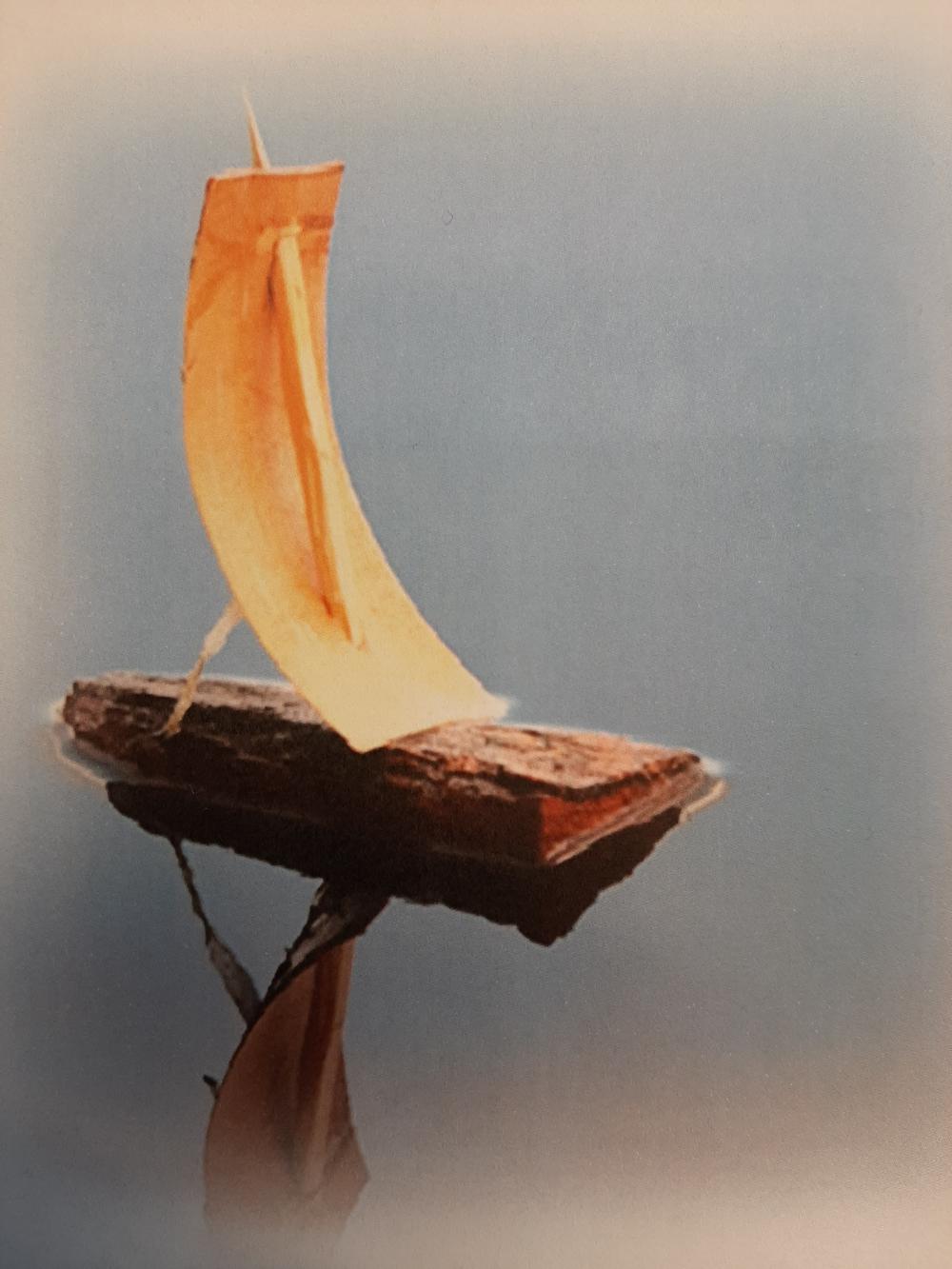 Kuvassa kaarnavene, jonka kuva heijastuu vedenpinnasta